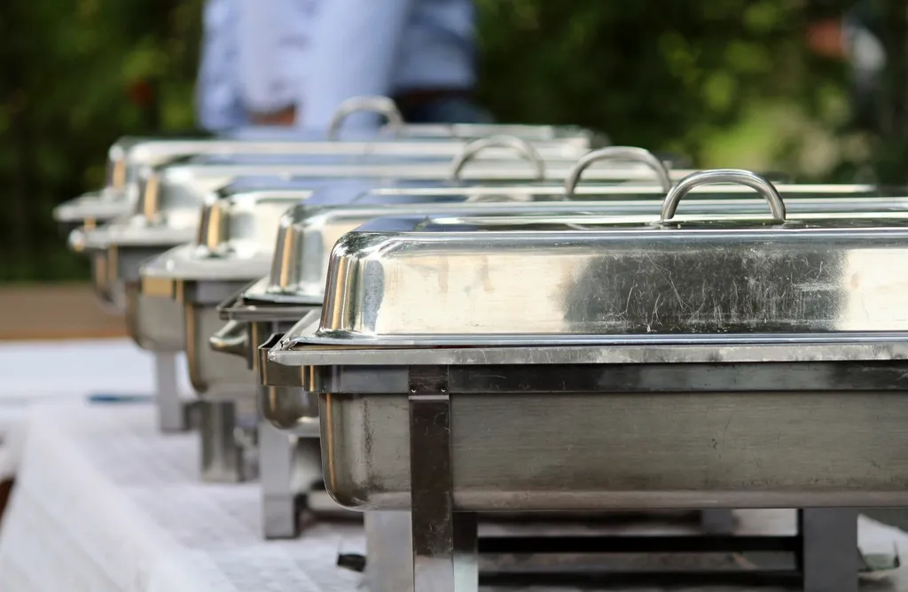 Row of steel chafing dishes set out on a catering buffet